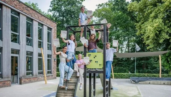 Kinderen tonen trots hun typediploma op het schoolplein.